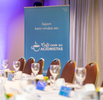 Photo of a banner in the background with the Café con los acionistas logo.